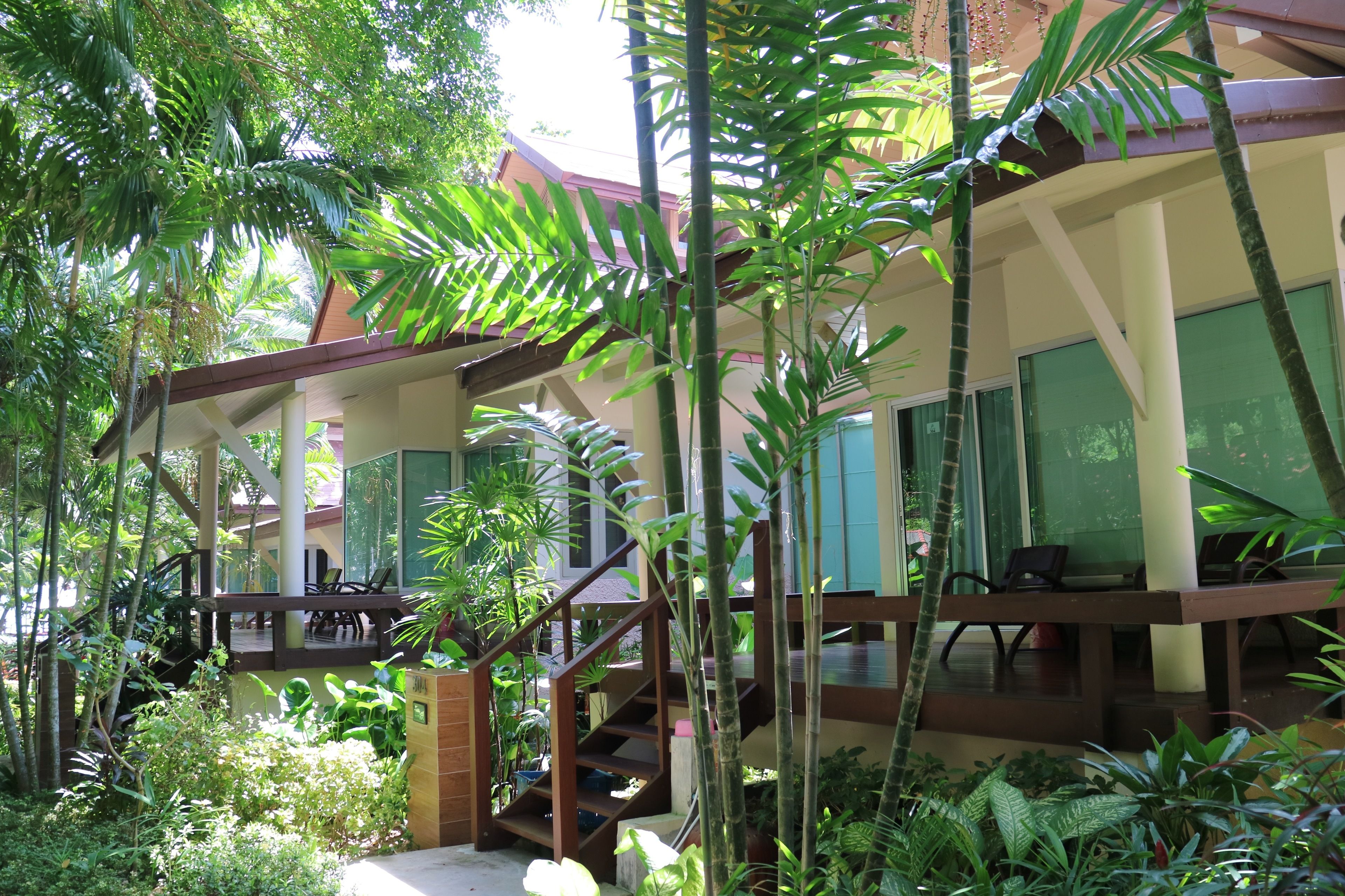 A multi-level building with a covered outdoor area surrounded by lush greenery.