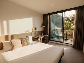 A hotel room with a large bed, a desk, and a view of the outdoors. - Alpha Mosaic Hotel Fortitude Valley (Fortitude Valley)