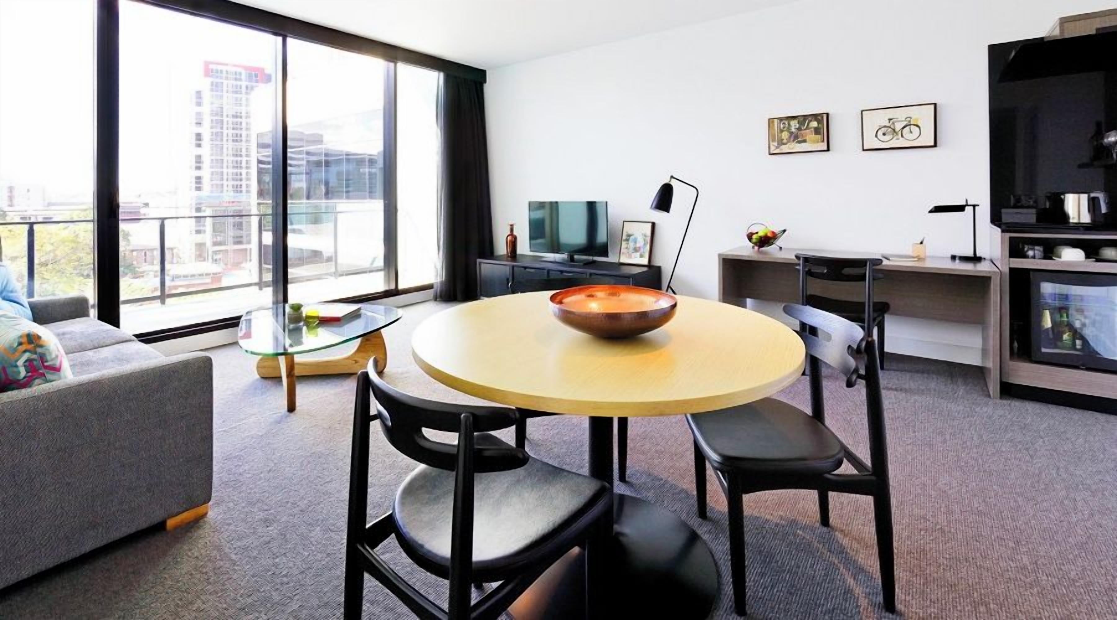 A modern living room with a round table, a sofa, and a television.