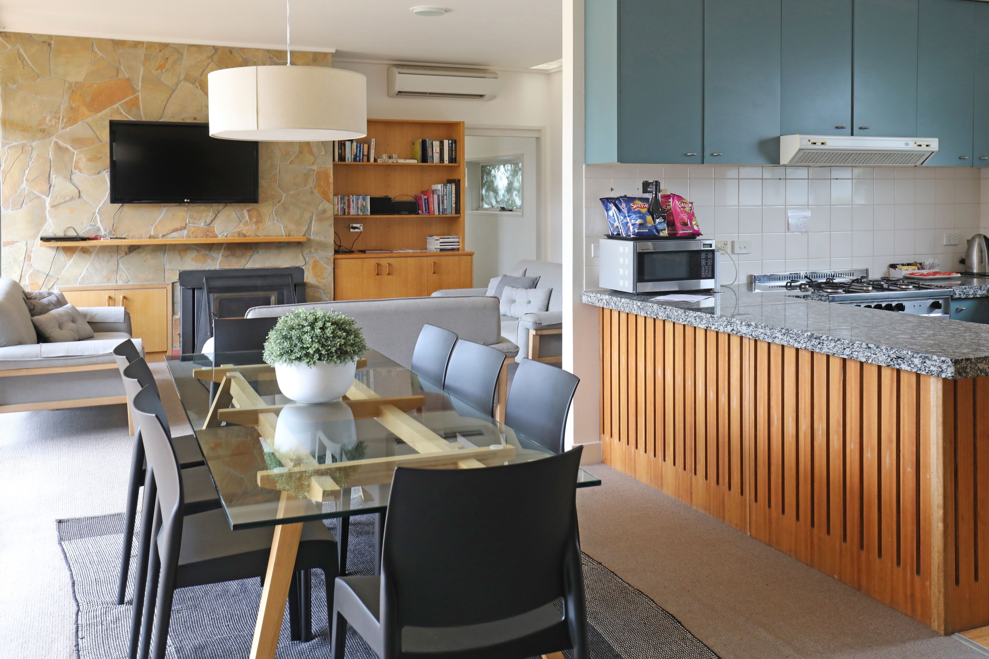 Una cocina moderna con protector de piedra, una isla integrada y un televisor de pantalla plana sobre la encimera.