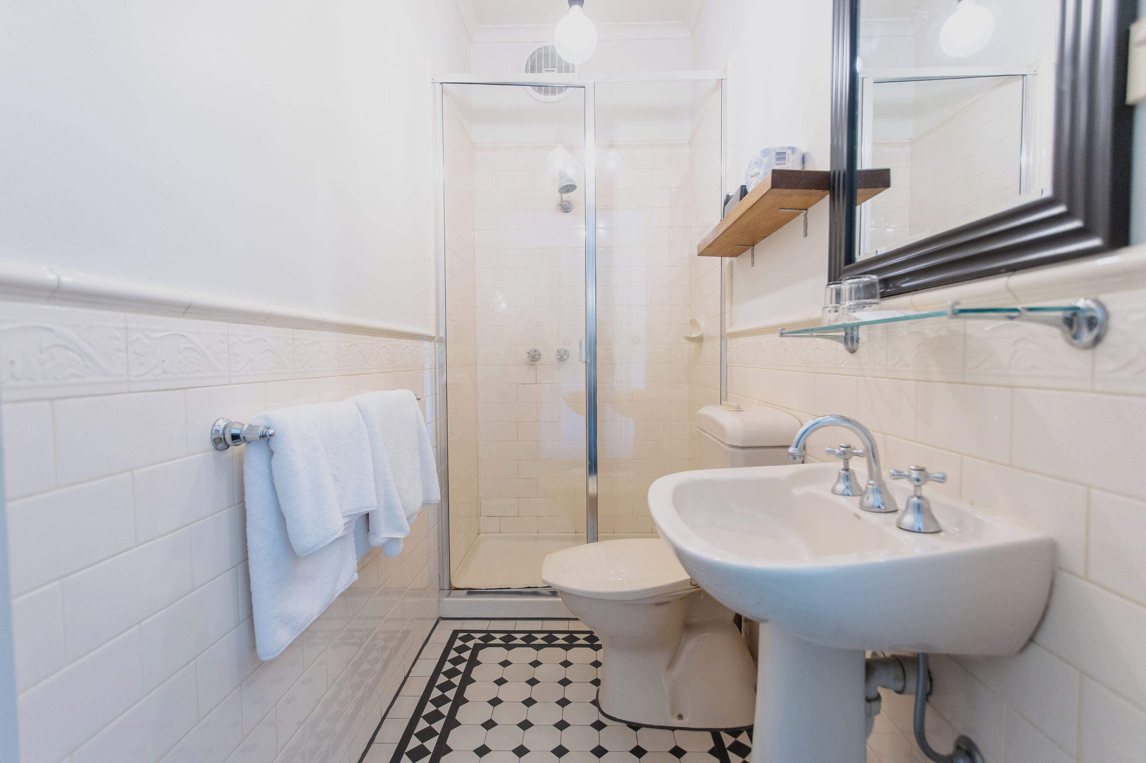 Un baño con ducha de vidrio, un lavabo blanco y un inodoro.