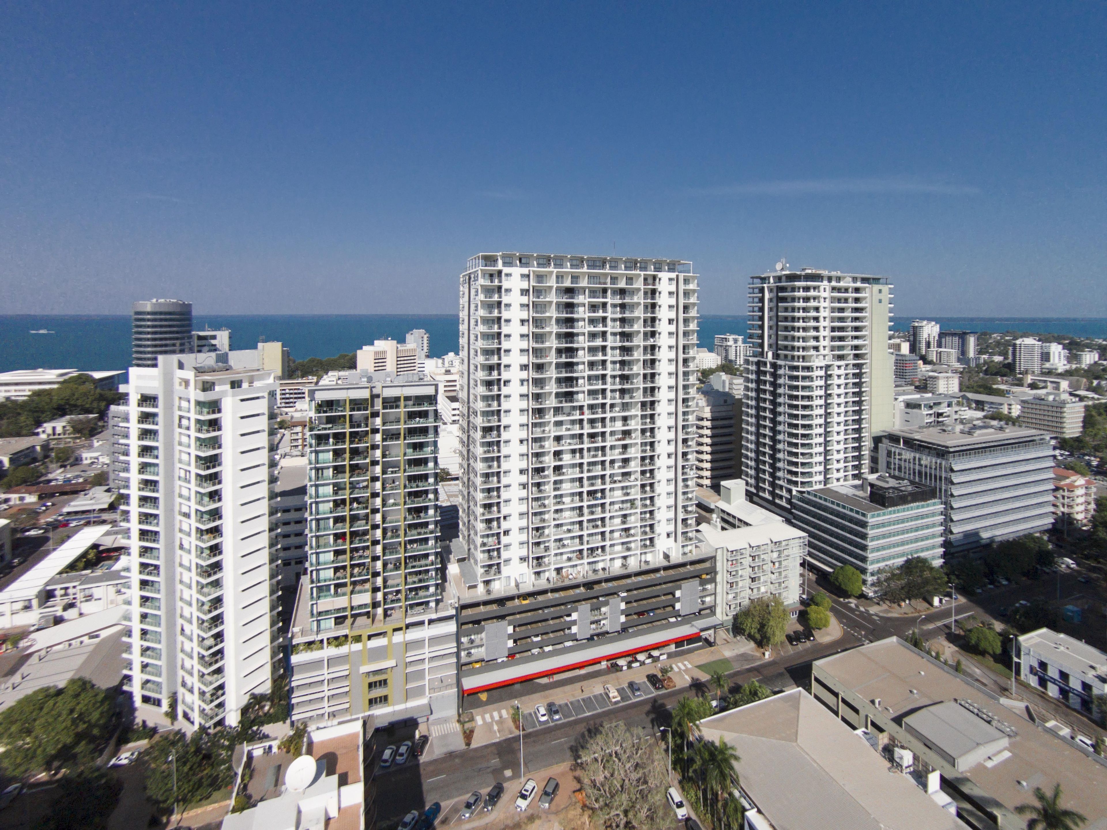 Un immeuble de grande hauteur, doté de nombreux étages, d’un espace de stationnement et offrant une vue sur la mer.
