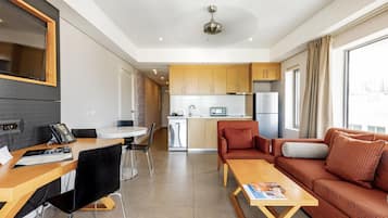A modern apartment with a dining area, kitchen, and living room.