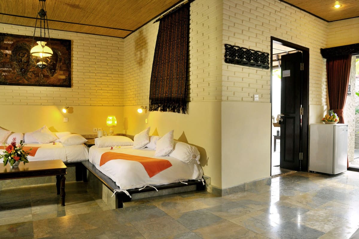 A hotel room with a bed, bedside tables, a desk, and a view of the outdoors.