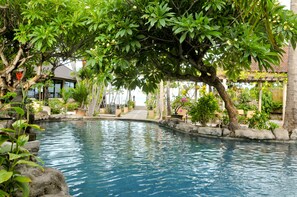 A serene pool area with a stone border, lush greenery, and a clear blue pool. - Hidden Paradise Cottages (Karangasem)