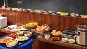 A buffet setup with various dishes and a steam pot. - APA Hotel Shimbashi Toranomon (Tokyo)