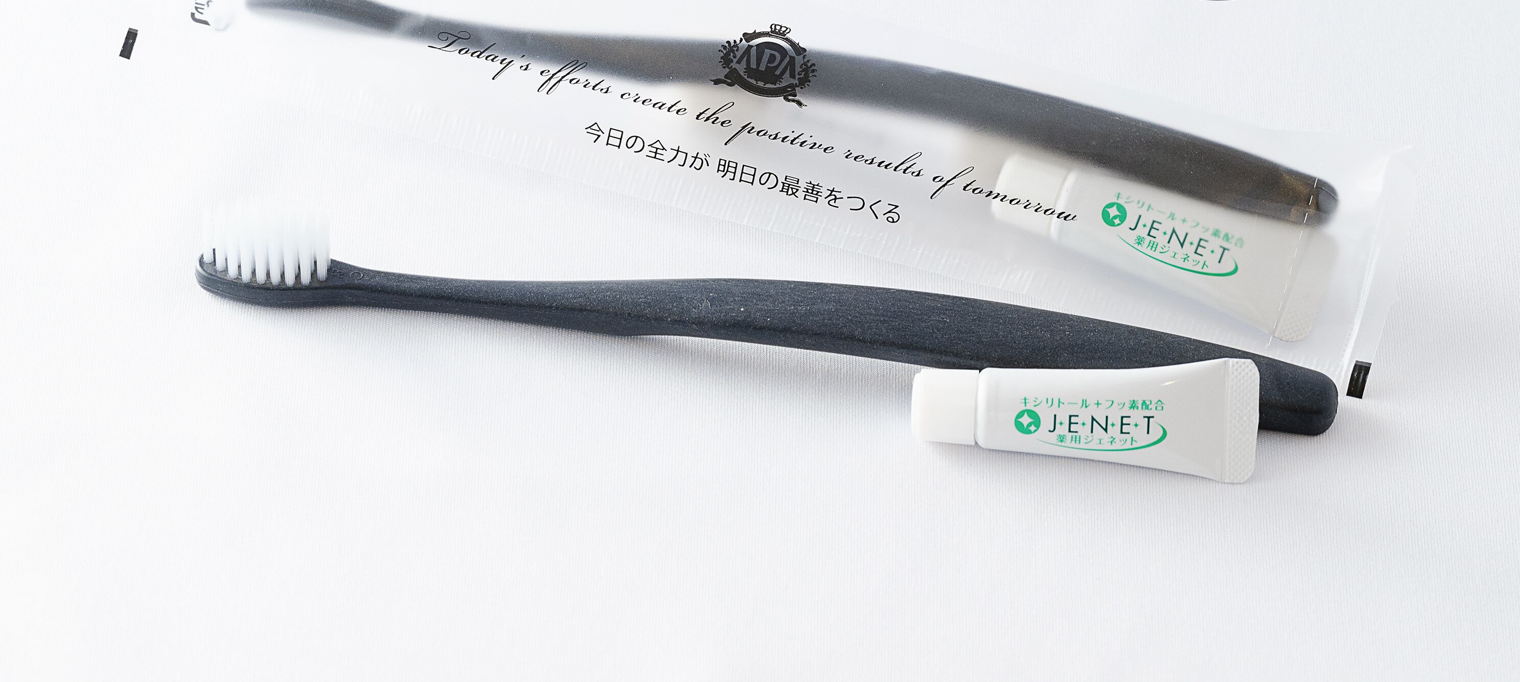 A toothbrush and its packaging with text in English and Japanese.