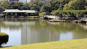 A serene park with a pond, a traditional building, and a bridge. - APA Hotel Shimbashi Toranomon (Tokyo)