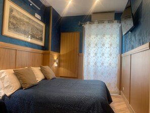A bedroom with a bed, wooden headboard, wall-mounted air conditioning unit, and a framed picture. - B&B A Casa di Barbara (Rome)