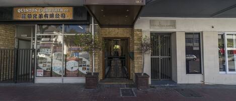 A building with a sign reading "Quinton & Brother" and another sign for "Cafe Vibe 182".
