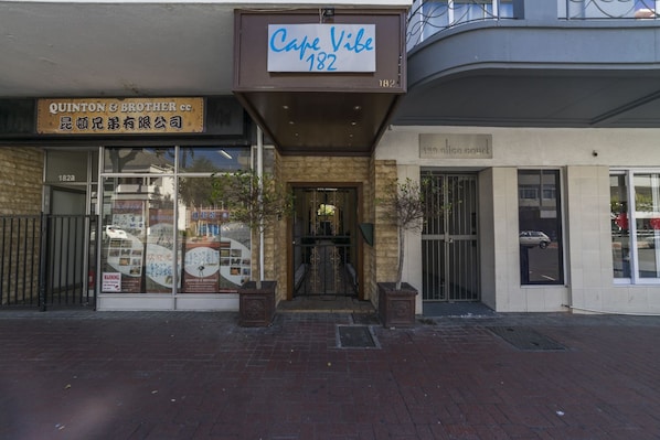 A building with a sign reading "Quinton & Brother" and another sign for "Cafe Vibe 182".