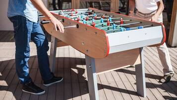 A foosball table outdoors with two players.