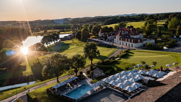 A golf course with a clubhouse, a swimming pool, and a parking area. - Relais des Vigiers (Monestier)