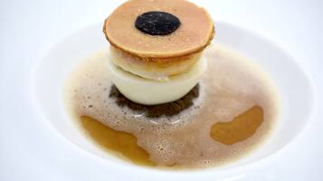 Un dessert avec une croûte caramélisée et un cœur coulant, servi dans une assiette blanche.