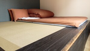 A bed with a dark wooden headboard, a beige mattress, and two brown pillows.