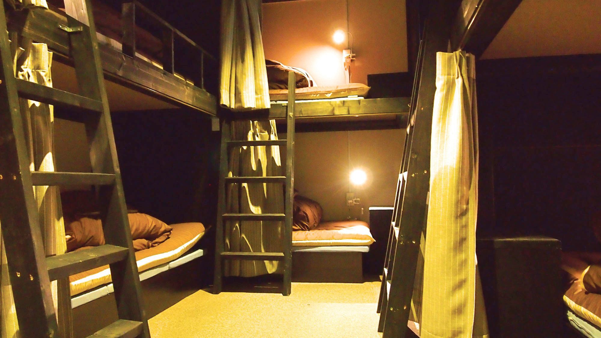 Une chambre avec un lit superposé, une échelle, un bureau et une lampe.