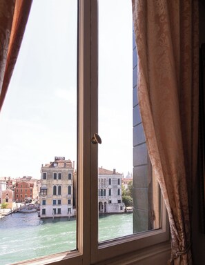 A window with a view of a canal and buildings in the background.