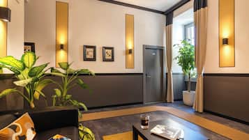 A modern hotel lobby with a sofa, a coffee table, and potted plants.