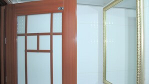 Une porte en bois avec un panneau en verre dépoli et un miroir encadré de doré accroché au mur.