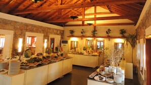 A spacious room with a high wooden ceiling, stone walls, and a buffet table with various dishes. - Okaliptus Hotel (Bodrum)