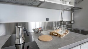 A modern kitchen with stainless steel appliances, a coffee maker, and a marble countertop. - Le Stanze del Duomo (Florence)