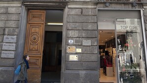 A building with a large wooden door and a shop window labeled "TOP GIRL". - Le Stanze del Duomo (Florence)