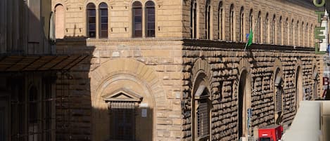 A historic building with a prominent arched entrance and a flag on top.