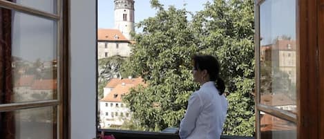 A room with a large window overlooking a tower and trees.