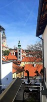 Vista desde un balcón sobre un pueblo con edificios históricos y una iglesia de cúpula verde.