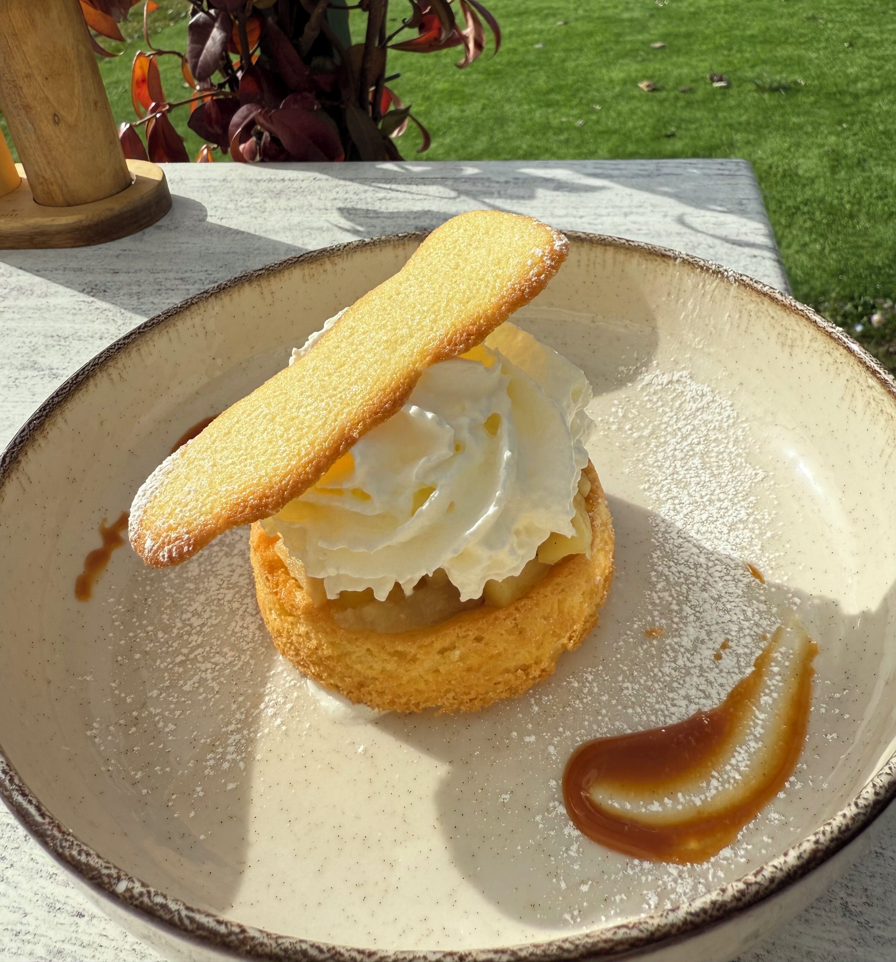 A dessert on a ceramic plate with a caramel sauce.