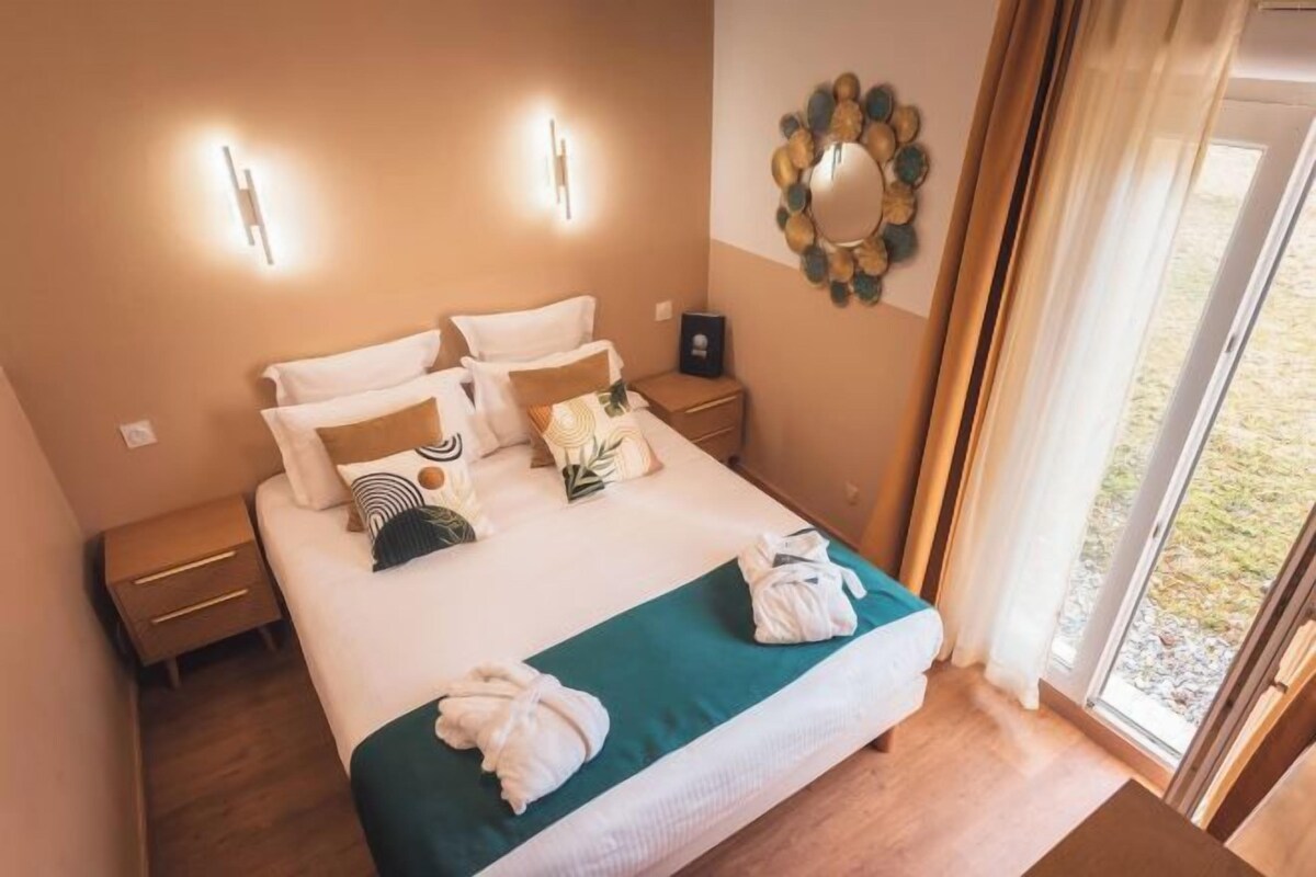 Une chambre d’hôtel avec un lit, des tables de chevet, un miroir et une vue sur l’extérieur.