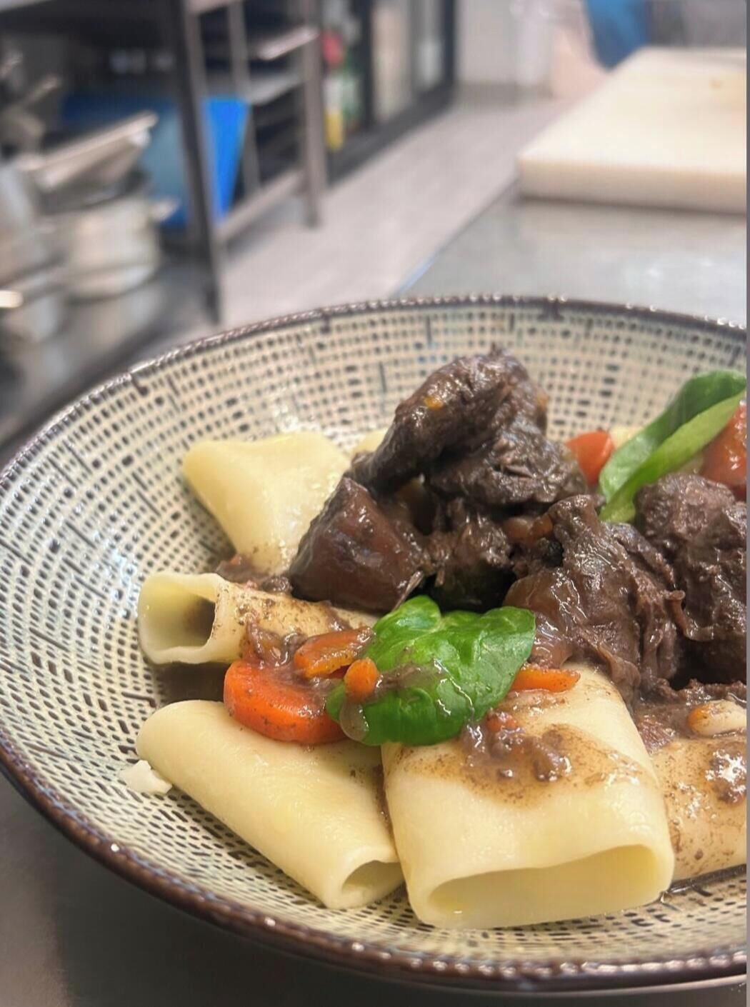 Un plato de pasta con carne y verduras.