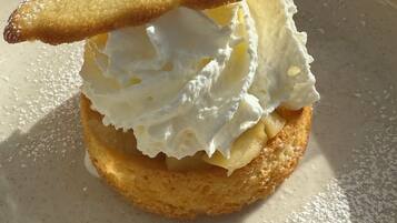Postre con crema batida y salsa de caramelo sobre un plato.