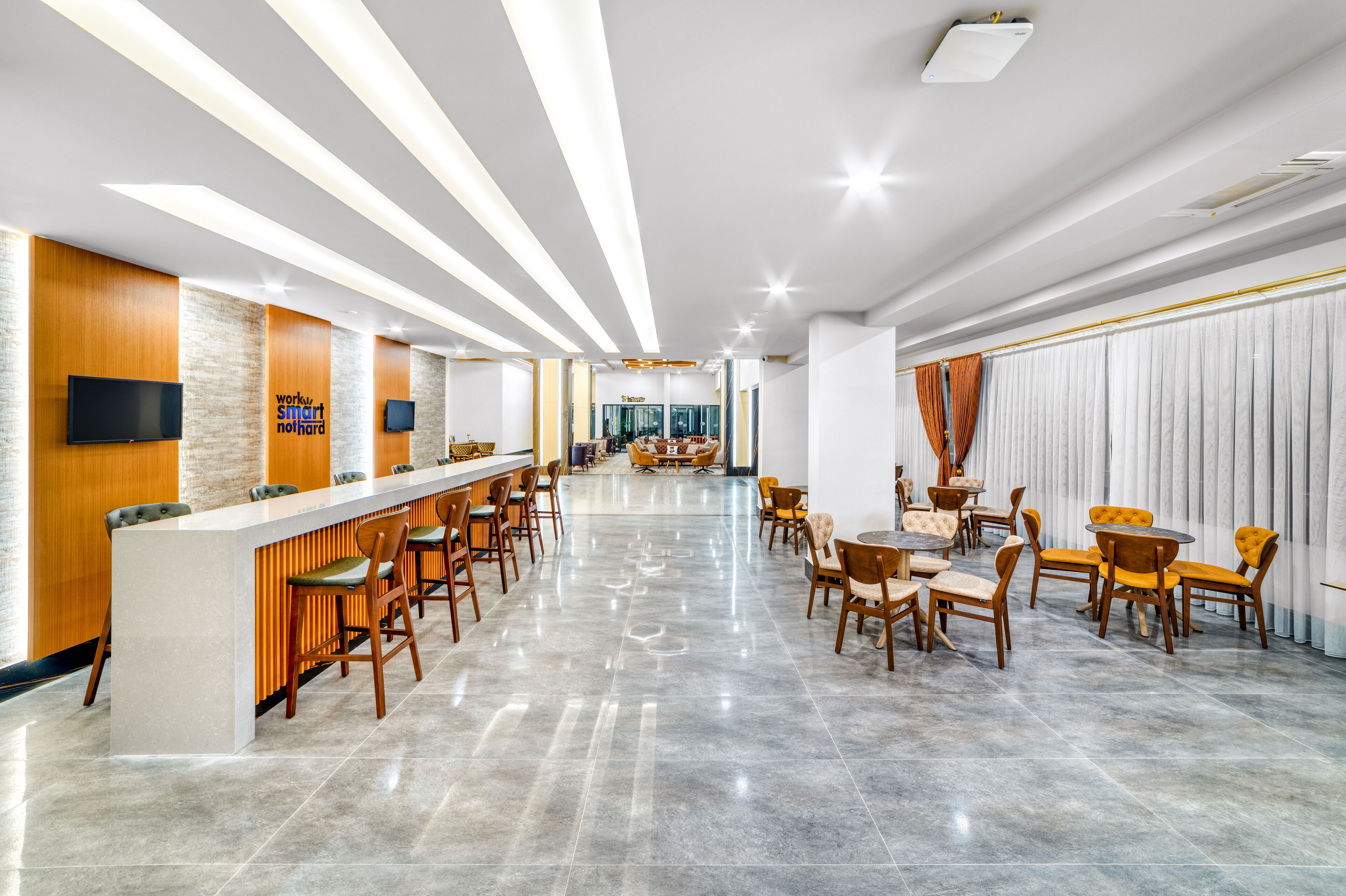 Un moderno vestíbulo de hotel con mostrador de recepción, zona de estar y un amplio ventanal.