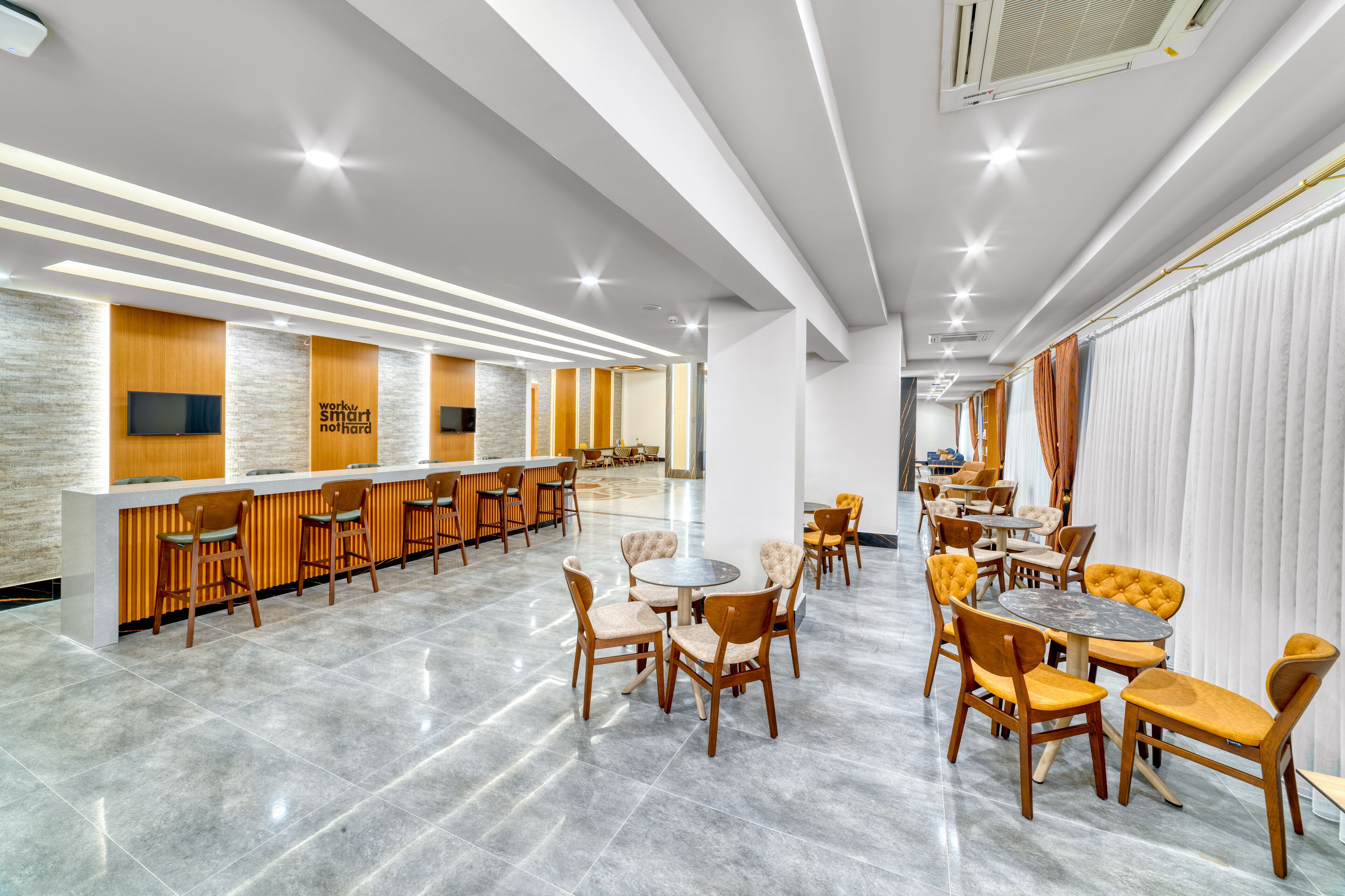 A modern hotel lobby with a bar area, seating arrangements, and a reception desk.