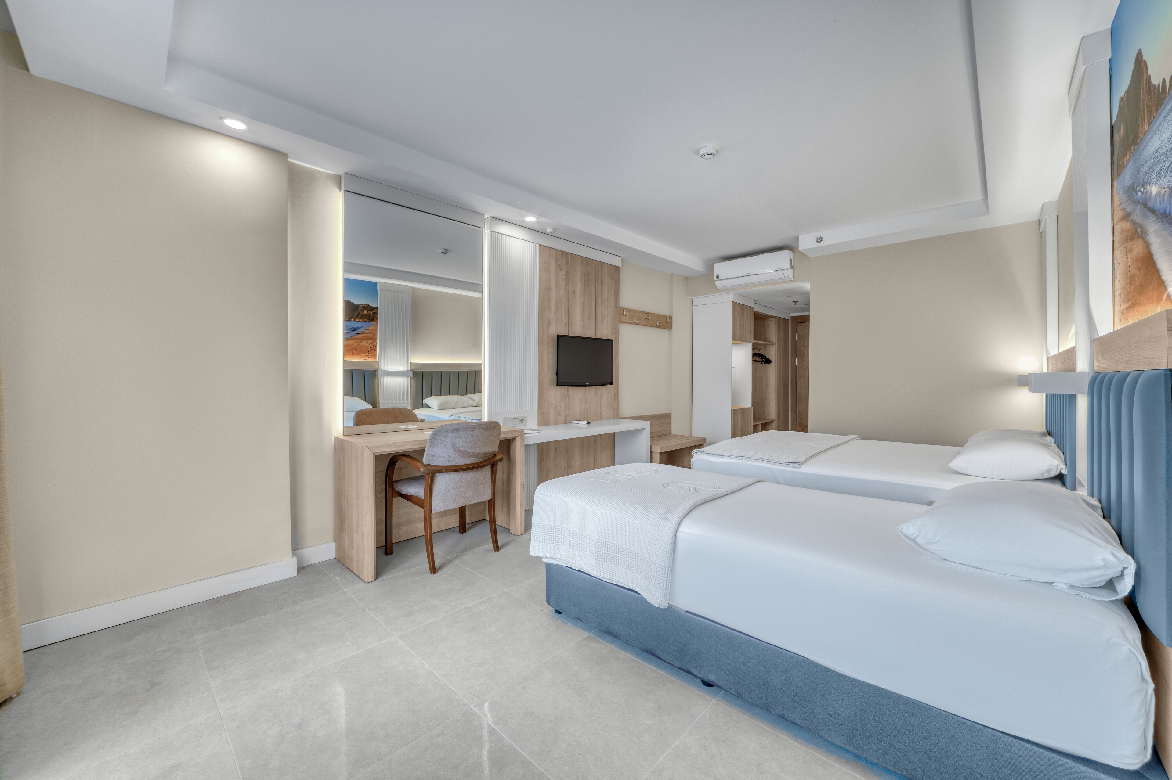 Una habitación de hotel con cama, escritorio, silla y televisor.