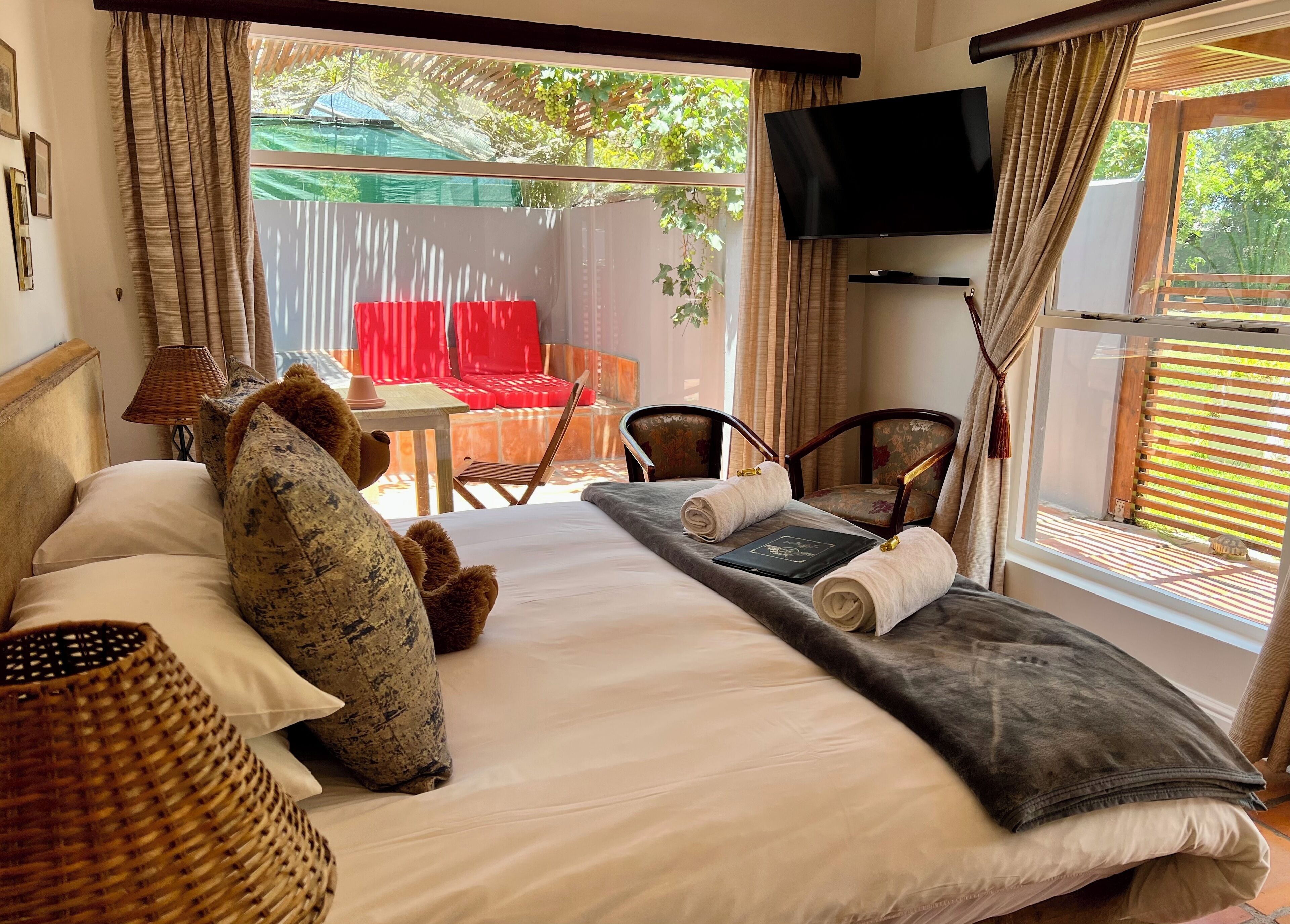 A hotel room with a bed, a TV mounted on the wall, and a view of the outdoors.