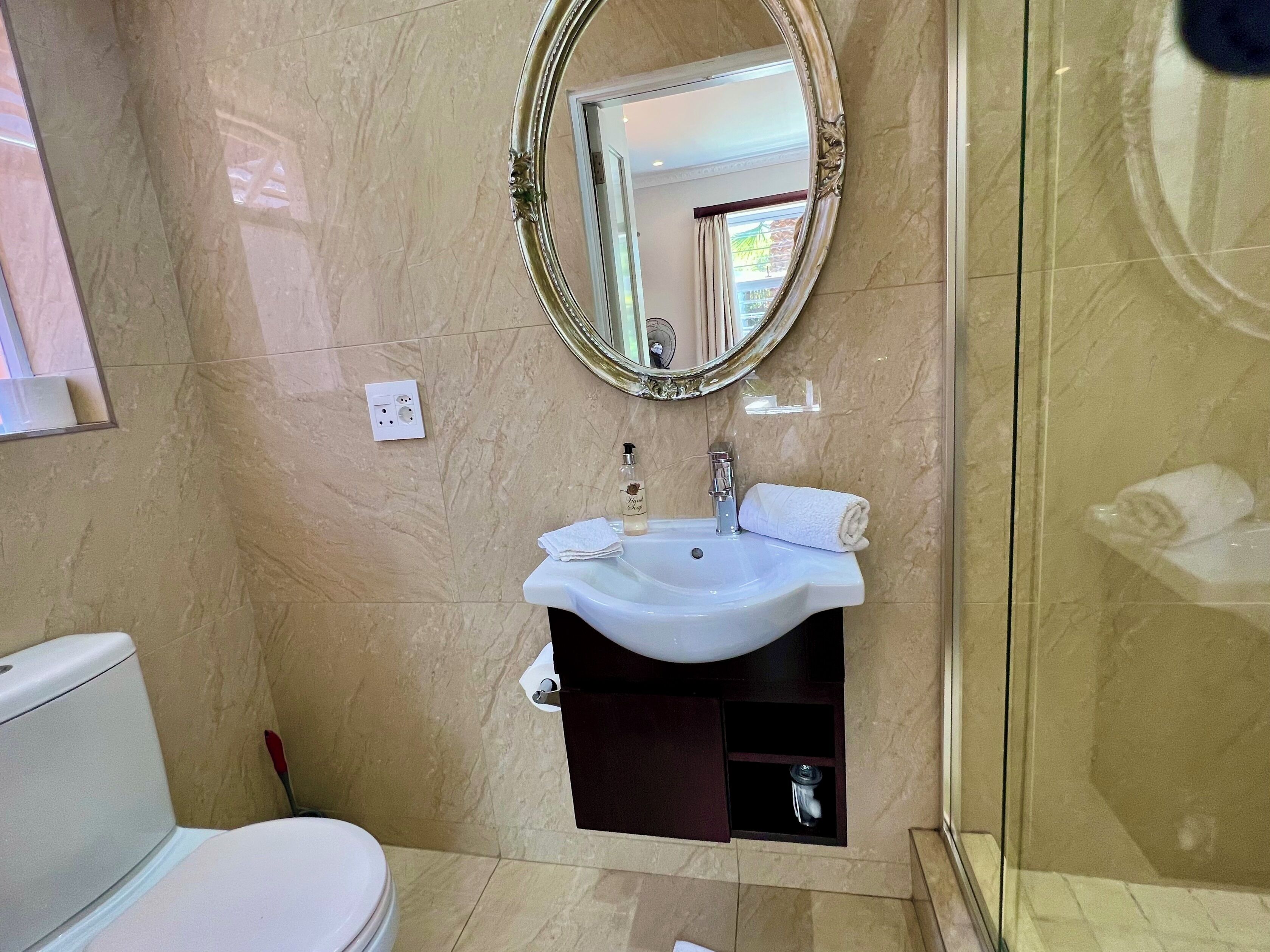 A bathroom with a white sink, a mirror, and a toilet.