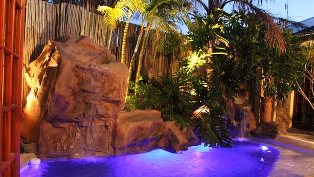 A pool with a rocky landscape and tropical plants. - Goblin's Mead (Cape Town)