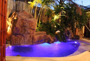 A pool with a rocky landscape and tropical plants. - Goblin's Mead (Cape Town)