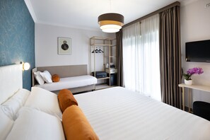 A hotel room with a large bed, a bedside table, a TV, a wardrobe, and a desk with a chair. - Roof Garden Zaccardi (Rome)