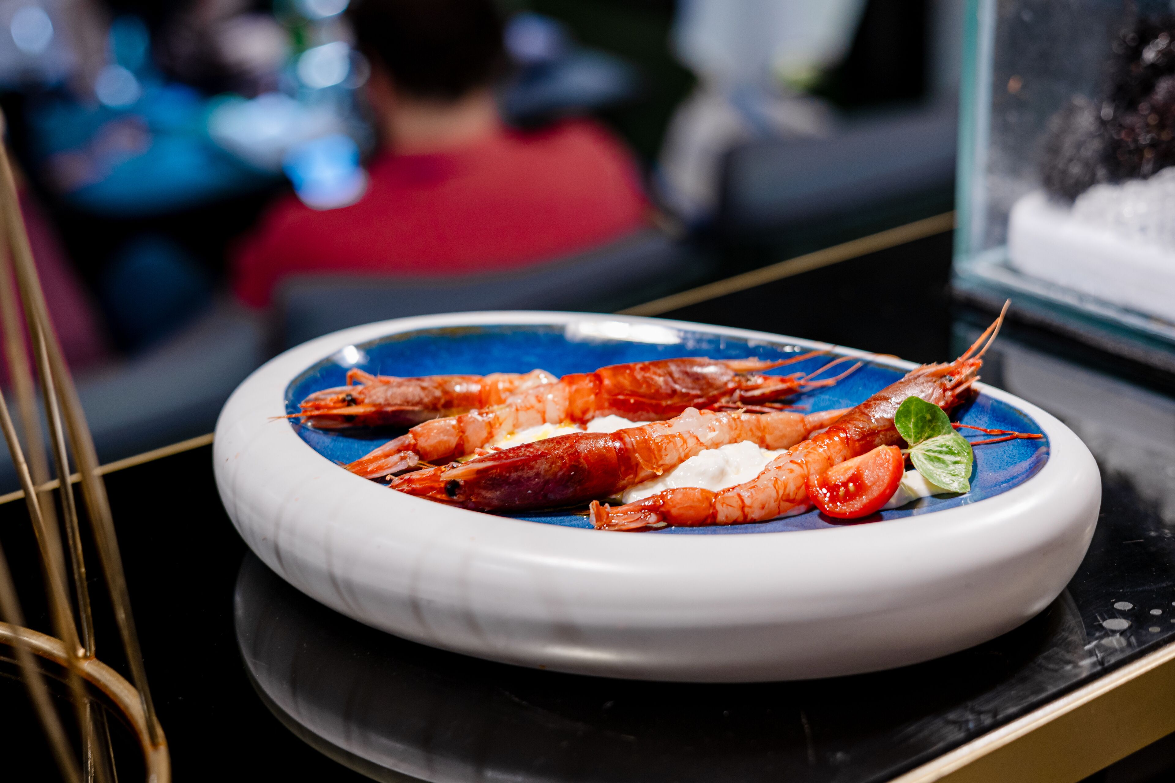 A plate of cooked shrimp on a blue and white ceramic dish.