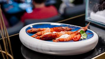A plate of cooked shrimp on a blue and white ceramic dish.