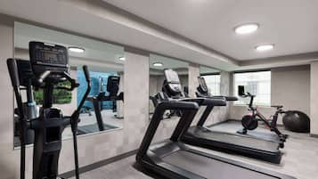 A gym with treadmills, an elliptical, and a stationary bike.