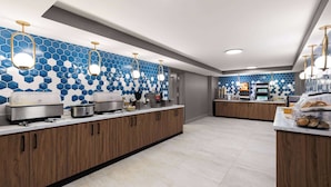 A modern kitchen with hexagonal blue tiles, wooden cabinets, and stainless steel appliances. - La Quinta Inn & Suites by Wyndham Knoxville Papermill (Knoxville)