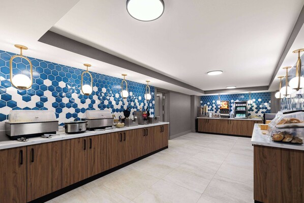 Una cocina moderna con azulejos hexagonales azules, armarios de madera y electrodomésticos de acero inoxidable.