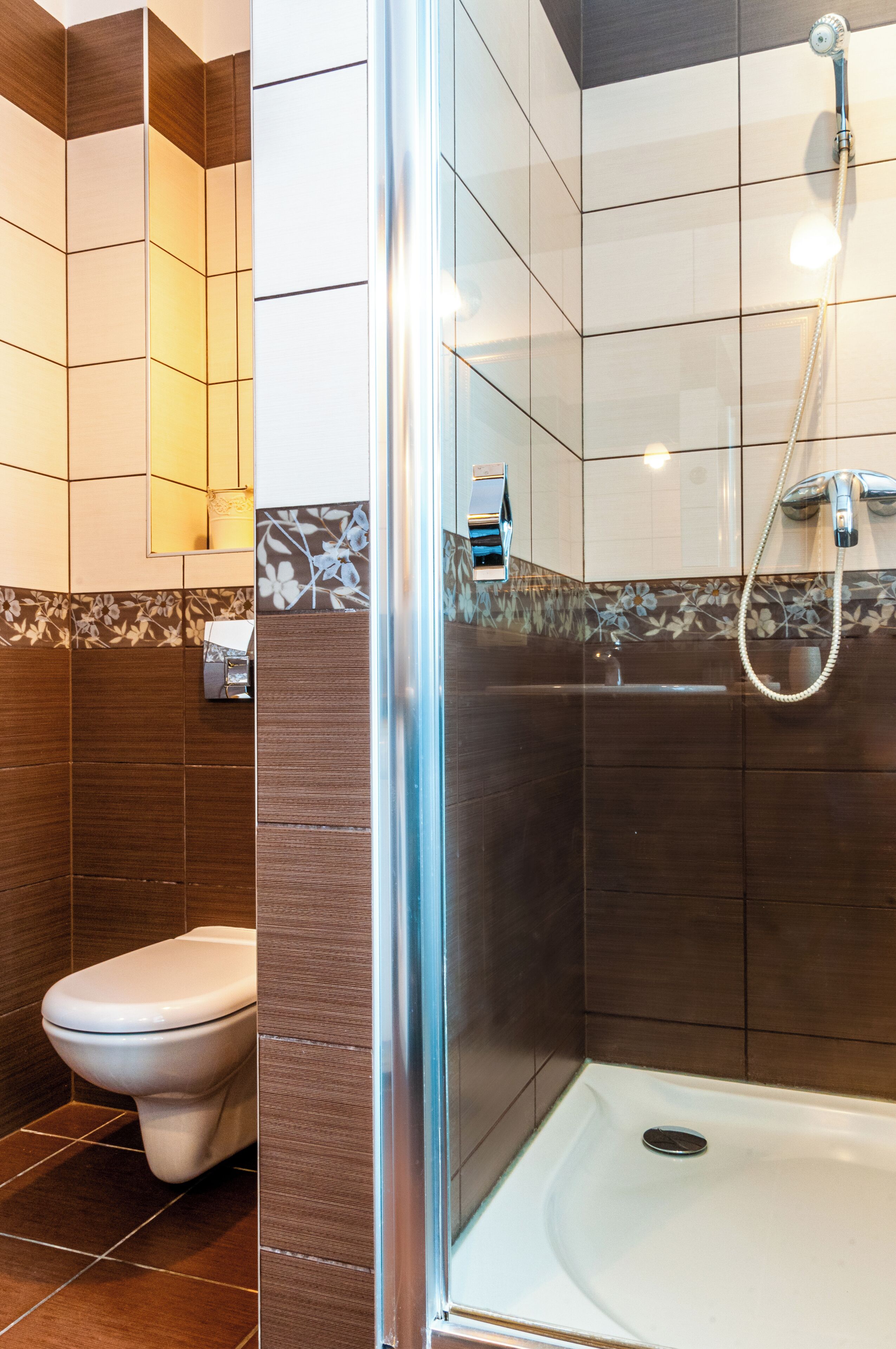 A modern bathroom with a glass-enclosed shower, a toilet, and a sink.
