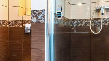 A modern bathroom with a glass-enclosed shower, a toilet, and a sink.
