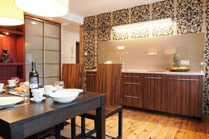 Superior studio | Privékeuken | Een koelkast, een kookplaat, kookgerei, borden en bestek