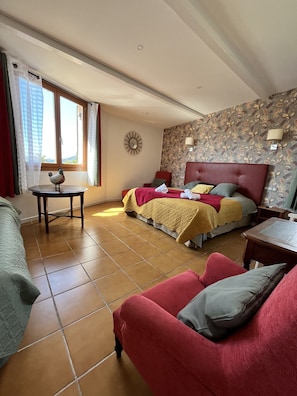 A hotel room with a bed, two chairs, a small table, and a window with curtains. - Le Patio (Theoule-sur-Mer)